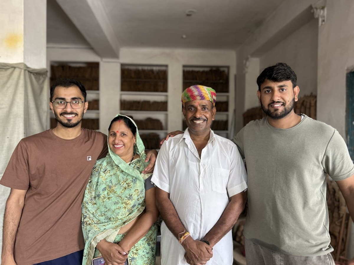 Umesh Kumhar with mother Kailash Devi, father Dinesh Chandra Kumhar, and family in the Molela studio