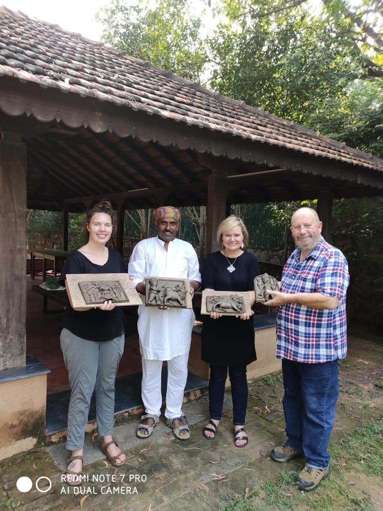 Dinesh Chandra Kumhar with international art students and collectors presenting handcrafted Molela terracotta plaques