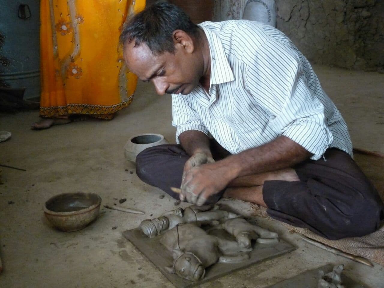 Master artisan Dinesh Chandra Kumhar sculpting a traditional Molela terracotta votive plaque in his workshop