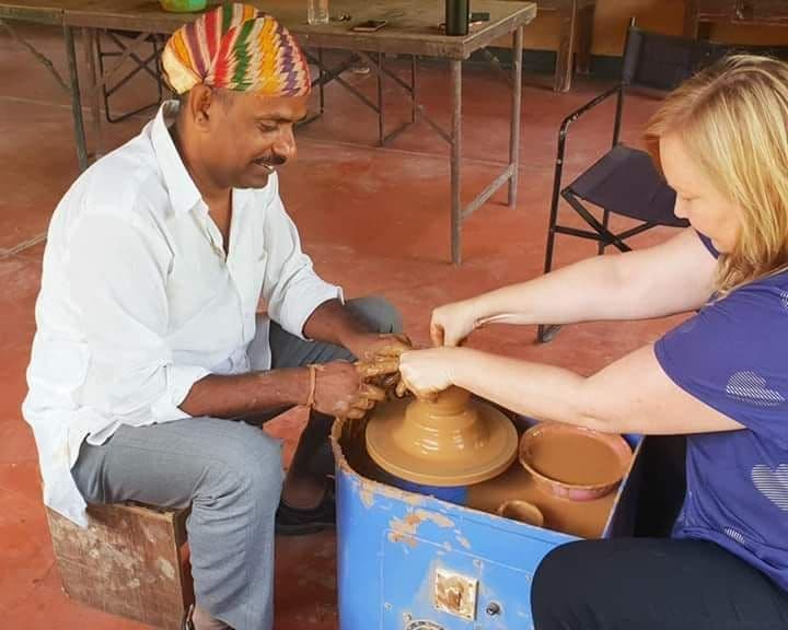 Dinesh Chandra Kumhar conducting a terracotta pottery workshop and mentoring a student at the wheel