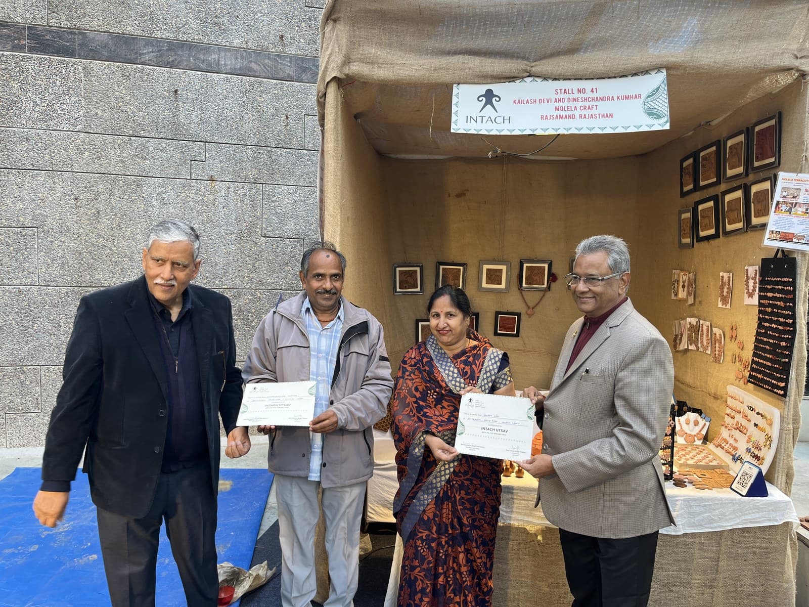 Dinesh Chandra Kumhar and Kailash Devi receiving the INTACH Utsav certificate at their Molela craft exhibition stall